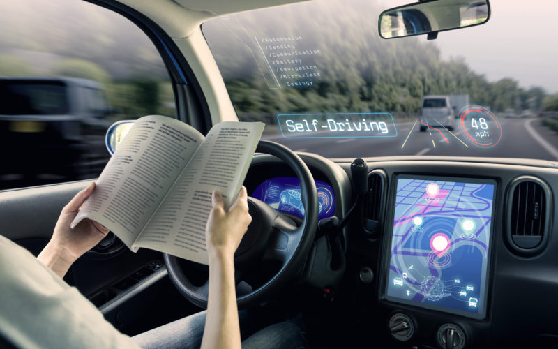 Women reading in a self driving car - TripJohn